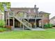 Spacious brick home featuring a walkout basement, a deck with stairs, and a lush green lawn at 3006 Cambridge Hill Dr, Dacula, GA 30019