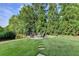 Lush backyard with a stone fire pit and mature trees at 3006 Cambridge Hill Dr, Dacula, GA 30019