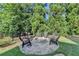 Lush backyard with a stone fire pit and mature trees at 3006 Cambridge Hill Dr, Dacula, GA 30019