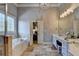 Bright bathroom featuring a tub, decorative window, double sinks, and stylish vanity lighting at 3006 Cambridge Hill Dr, Dacula, GA 30019