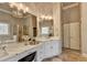 Elegant bathroom featuring double sinks, a makeup vanity, mirrors, and a separate shower and tub at 3006 Cambridge Hill Dr, Dacula, GA 30019