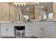 Elegant bathroom featuring a vanity with white cabinets, marble countertop, and a large mirror with decorative lighting at 3006 Cambridge Hill Dr, Dacula, GA 30019