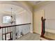 Upstairs hallway featuring a decorative chandelier, wrought iron banister, and views of the front entry at 3006 Cambridge Hill Dr, Dacula, GA 30019
