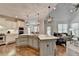 Modern kitchen with white cabinetry, stainless steel appliances, an island, and open to the living room at 3006 Cambridge Hill Dr, Dacula, GA 30019