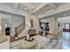 Open-concept living area with hardwood flooring, detailed trim, and an adjacent staircase at 3006 Cambridge Hill Dr, Dacula, GA 30019