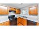 Well-lit kitchen with an oven, dishwasher, wooden cabinets, and dual stainless steel sinks at 735 Crestwell Sw Cir, Atlanta, GA 30331