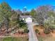 An aerial view of a single Gathering home with a long driveway and a well landscaped front yard at 7750 Silversmith Dr, Cumming, GA 30028