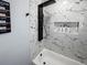 Modern bathroom with marble tile, a luxurious shower system and a soaking tub at 7750 Silversmith Dr, Cumming, GA 30028