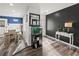 Bright entryway features wood floors, black accent wall, unique décor, and adjacent dining area with natural light at 7750 Silversmith Dr, Cumming, GA 30028