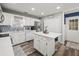 Bright kitchen features white cabinets, stainless appliances, island with seating, and decorative tile backsplash at 7750 Silversmith Dr, Cumming, GA 30028