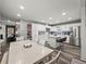 Bright kitchen features white cabinets, stainless appliances, island with seating, and decorative tile backsplash at 7750 Silversmith Dr, Cumming, GA 30028