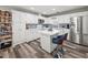 Bright kitchen features white cabinets, stainless appliances, island with seating, and decorative tile backsplash at 7750 Silversmith Dr, Cumming, GA 30028