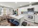 Bright kitchen features white cabinets, stainless appliances, island with seating, and decorative tile backsplash at 7750 Silversmith Dr, Cumming, GA 30028
