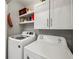 Bright laundry room with updated washer and dryer units and ample storage cabinets at 7750 Silversmith Dr, Cumming, GA 30028