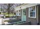 Inviting exterior showcases a brick home with a stylish green door, planter boxes, patio seating, and blossoming trees at 20 Screven Ne St, Atlanta, GA 30307