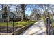 Beautiful home with a lush green lawn, gated entrance and long driveway framed by mature trees at 20 Screven Ne St, Atlanta, GA 30307
