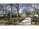 Beautiful home with a lush green lawn, gated entrance and long driveway framed by mature trees at 20 Screven Ne St, Atlanta, GA 30307