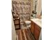 A bathroom with a wooden vanity and a floral shower curtain at 315 Saratoga Pl, Riverdale, GA 30296