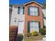 A two-story townhome featuring a brick facade, white siding, and dark green shutters at 315 Saratoga Pl, Riverdale, GA 30296