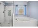 Modern bathroom featuring a shower with glass door and a bathtub under a window with blue curtains at 1421 Briarcliff Dr, Woodstock, GA 30189