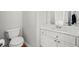 Clean, neutral bathroom with a white vanity, a matching toilet, and a framed mirror at 1421 Briarcliff Dr, Woodstock, GA 30189