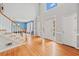 Bright entryway with hardwood floors, staircase with white railings, and high ceiling with transom window at 1421 Briarcliff Dr, Woodstock, GA 30189