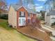 A lovely angle showcasing this brick home with a beautiful lawn and a mature tree at 1421 Briarcliff Dr, Woodstock, GA 30189