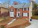 Inviting brick home with a manicured lawn and charming front entrance with landscaped retaining wall at 1421 Briarcliff Dr, Woodstock, GA 30189