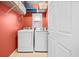 A bright laundry room with modern washer and dryer, and overhead shelving at 1421 Briarcliff Dr, Woodstock, GA 30189