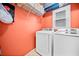 Laundry room with modern appliances, overhead shelf, and window at 1421 Briarcliff Dr, Woodstock, GA 30189