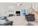 Spacious living room boasts a brick fireplace, modern entertainment center, and adjacent staircase at 1421 Briarcliff Dr, Woodstock, GA 30189
