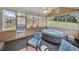 Charming sun room with a hot tub, tiled flooring, and large windows overlooking the landscaped backyard at 1421 Briarcliff Dr, Woodstock, GA 30189