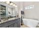 Bathroom with a freestanding tub, granite counters, and a large mirror at 1450 Donald Lee Hollowell Nw Pkwy, Atlanta, GA 30318