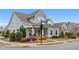 Corner view of charming blue home featuring inviting front porch and beautiful, well-manicured landscaping at 200 Oakside Way, Lawrenceville, GA 30046