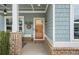 Inviting covered front porch featuring brick pillars, charming decor, and a welcoming entrance at 200 Oakside Way, Lawrenceville, GA 30046