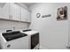 Modern laundry room with washer and dryer, plus overhead cabinets at 200 Oakside Way, Lawrenceville, GA 30046