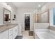 Bright main bathroom with double vanity, glass enclosed shower and a soaking tub at 200 Oakside Way, Lawrenceville, GA 30046
