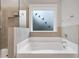 Soaking tub with glass-enclosed shower and a window with bird silhouette stickers at 200 Oakside Way, Lawrenceville, GA 30046