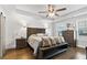 Comfortable main bedroom features a ceiling fan, hardwood floors and a wooden bench at the end of the bed at 200 Oakside Way, Lawrenceville, GA 30046