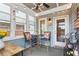 Bright sunroom with tile flooring, string lights, blue chair cushions, and a white door at 200 Oakside Way, Lawrenceville, GA 30046