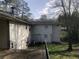 Side view of the house featuring a small back deck and lower level access at 2076 Dobbins Nw Dr, Kennesaw, GA 30144