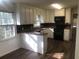 Bright kitchen featuring white cabinets, a gas range, and new looking floors at 2076 Dobbins Nw Dr, Kennesaw, GA 30144