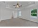Bright bedroom featuring large windows, tray ceilings, ceiling fan and neutral carpet flooring at 380 Waterbluff Dr, Mableton, GA 30126
