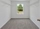 This closet features white wire shelving, gray carpet, a window, and white walls at 380 Waterbluff Dr, Mableton, GA 30126