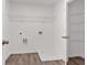 This laundry room features wood-look floors, hookups, shelving, and white walls at 380 Waterbluff Dr, Mableton, GA 30126