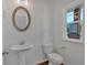 Neat powder room featuring a pedestal sink, standard toilet, oval mirror and hardwood flooring at 380 Waterbluff Dr, Mableton, GA 30126
