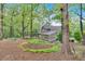 Backyard landscape with a home featuring a sunroom addition, outdoor dining, and lush greenery at 3951 Lorien Nw Way, Kennesaw, GA 30152