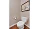 A half bathroom with a toilet, hardwood floors, and picture on the wall at 3951 Lorien Nw Way, Kennesaw, GA 30152