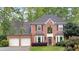 Charming two-story red brick home with an attached two-car garage and beautifully landscaped front yard at 3951 Lorien Nw Way, Kennesaw, GA 30152
