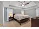 Serene main bedroom featuring a tray ceiling, ceiling fan, and large windows, creating a relaxing space at 3951 Lorien Nw Way, Kennesaw, GA 30152